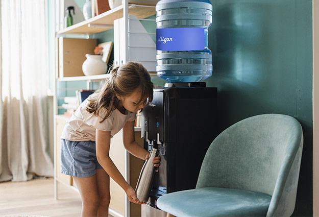 Enfant qui remplit sa bouteille depuis la fontaine à eau